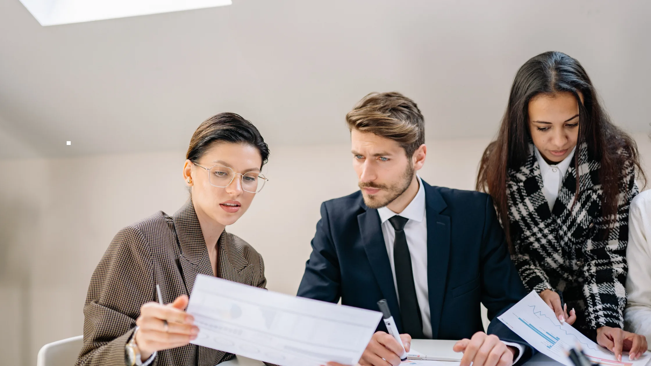 A diverse team of corporate professionals analyzing performance data and business strategy, illustrating the core objective of talent management services to optimize human capital in the workplace.