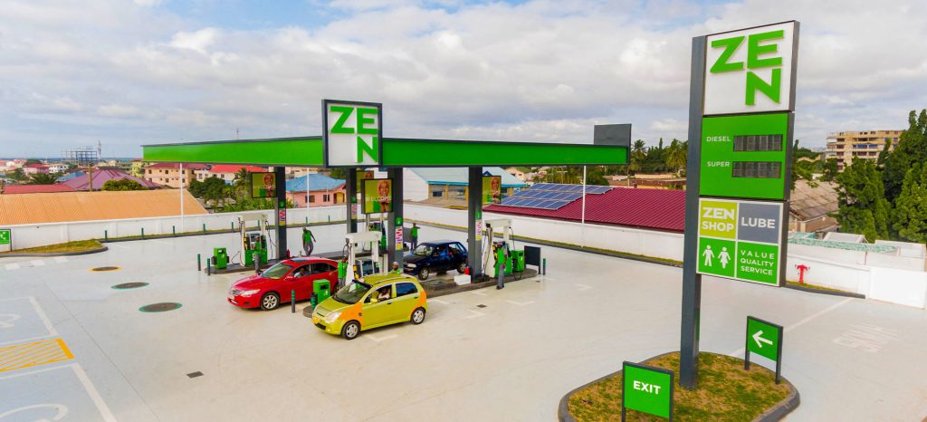 A wide aerial view of a modern ZEN Petroleum retail station featuring green branding and a digital price board, showcasing the physical expansion and market presence that fueled the record-breaking ZEN Petroleum IPO.