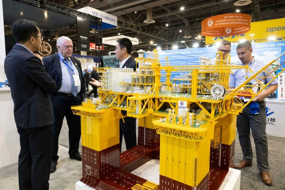 Industry professionals discussing deepwater drilling models at the Offshore Technology Conference 2026 in Houston, showcasing the latest subsea engineering and platform technology.