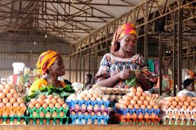 Market traders in Nigeria arranging crates of eggs, illustrating how Nigerian SMEs can scale successfully from grassroots markets to larger operations.