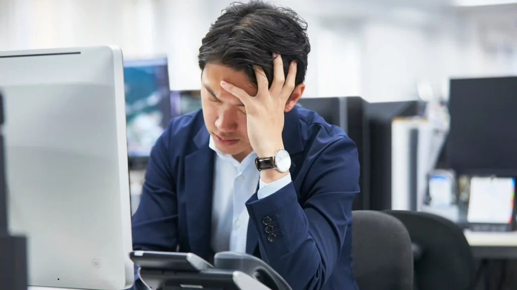 stressed office employee illustrating workplace stress, employee burnout, workload pressure, and productivity challenges in a modern corporate environment.