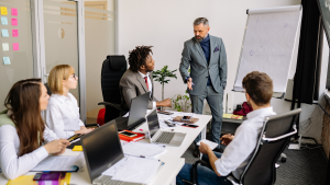 A diverse corporate team in an office meeting collaborating on cross-border workforce compliance strategies using global staff management services.