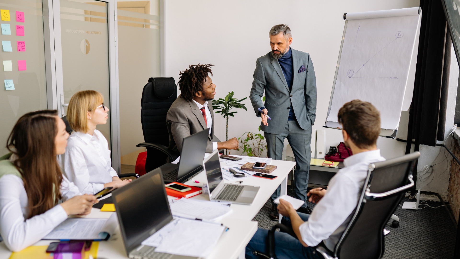 A diverse corporate team in an office meeting collaborating on cross-border workforce compliance strategies using global staff management services.