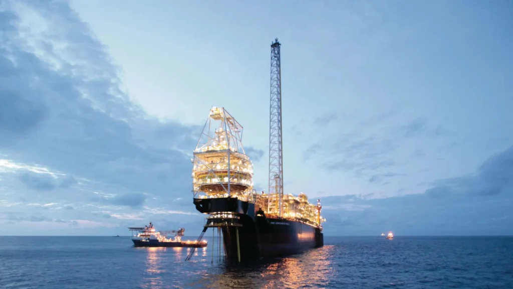 Illuminated offshore FPSO vessel operating at dusk