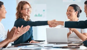 Business team shaking hands and applauding after agreeing a plan for hiring in Ghana and Nigeria