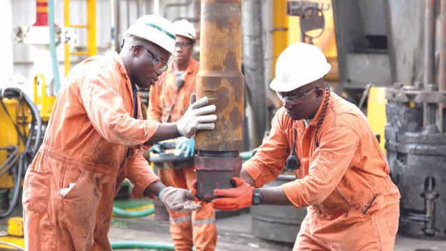 Nigeria upstream oil reforms supporting offshore oil and gas operations with workers handling drilling equipment.